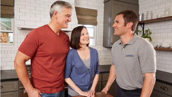 hvac tech talking with couple on kitchen